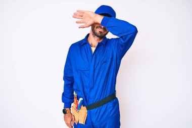 Kıvırcık saçlı ve ayı gibi giyinen yakışıklı genç adam kollarıyla gözlerini kapatıyor, ciddi ve üzgün görünüyor. Görme, saklama ve reddetme konsepti 