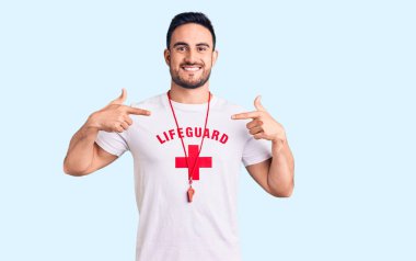 Cankurtaran üniforması giyen genç yakışıklı, kendine güvenen, yüzünde gülümseme olan, kendini gururlu ve mutlu gösteren bir adam.. 