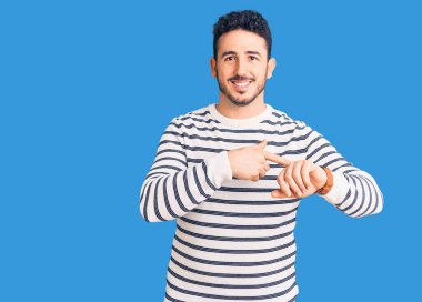 Gündelik giysiler giyen genç İspanyol adam saati, sabırsızlığı ve gecikmeyi izlemek için acele ediyor. 