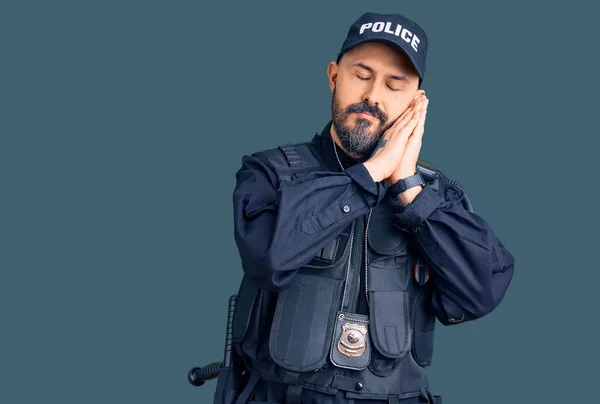 警官の制服を着た若いハンサムな男が夢を見ながら手でポーズをとりながら目を閉じて微笑む — ストック写真