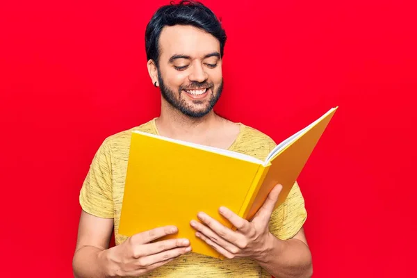 Young Hispanic Man Holding Book Looking Positive Happy Standing Smiling — Stock Photo, Image