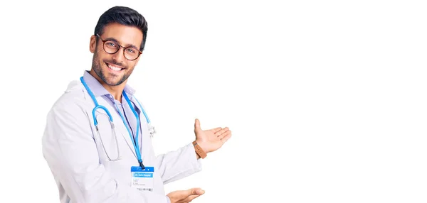 Jonge Spaanse Man Doktersuniform Stethoscoop Die Uitnodigt Met Open Hand — Stockfoto