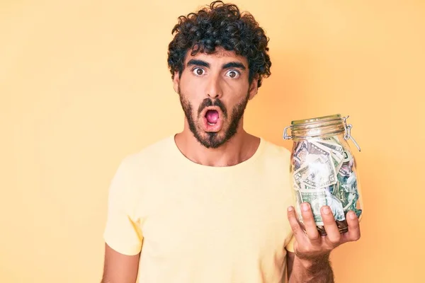 Handsome Young Man Curly Hair Bear Holding Jar Savings Scared — Stock Photo, Image