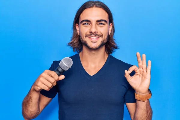 Joven Hombre Guapo Cantando Canción Usando Micrófono Haciendo Signo Con —  Fotos de Stock