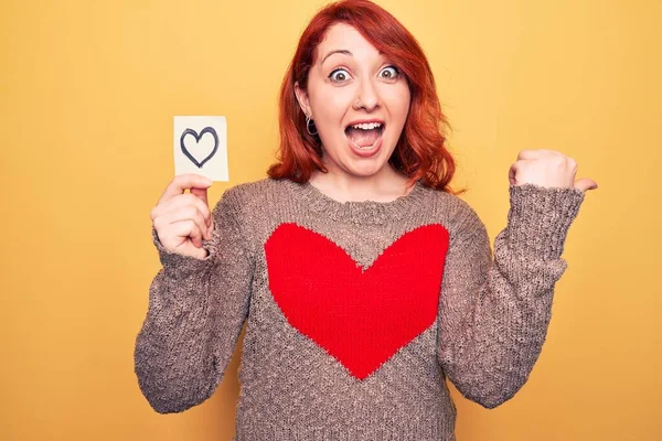 Giovane Bella Rossa Donna Tenendo Promemoria Con Cuore Sfondo Giallo — Foto Stock