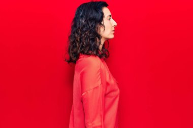 Genç ve güzel İspanyol bir kadın günlük giysiler giyiyor. Yan tarafa bakıyor, rahat bir poz veriyor. Kendine güvenen bir gülümsemesi var.. 