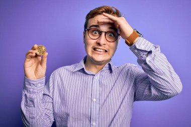 Mor zemin üzerinde kripto para taşıyan genç, kızıl saçlı işadamı. Eli kanlı, şaşırmış ve sinirli bir yüz.