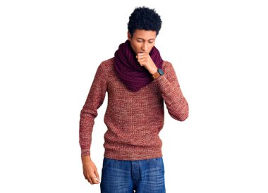 Genç Afro-Amerikan erkek, günlük kışlık kazak ve eşarp giyiyor ve kendini kötü hissediyor. Soğuk algınlığı veya bronşitin belirtisi olarak öksürüyor. sağlık hizmeti kavramı. 