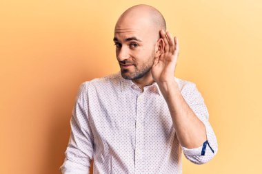 Zarif bir gömlek giymiş, kulağı kulağında gülümseyen, dedikodu ya da dedikoduları dinleyen yakışıklı kel bir adam. Sağırlık kavramı. 