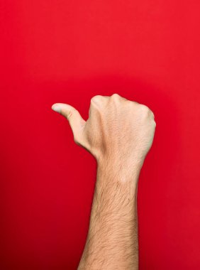 Güzel bir adam baş parmağıyla işaret veriyor.