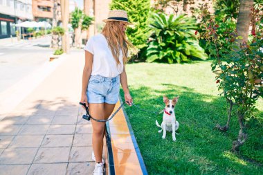 Genç, güzel, sarışın bir kadın bir yaz günü köpeği dışarı çıkartıyor.