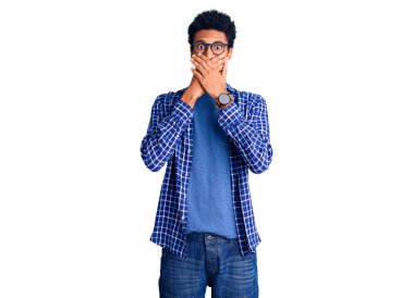 Sıradan kıyafetler ve gözlük takan genç Afro-Amerikalı adam yanlışlıkla ağzı ellerle kapatarak şok etti. gizli kavram. 