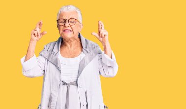 Son sınıf güzeli, mavi gözlü, gri saçlı, günlük kıyafetler giyen, gözlüklü, umut dolu ve gözleri kapalı bir şekilde gülümseyen güzel bir kadın. Şans ve batıl inançlar. 