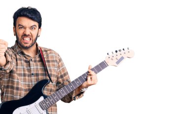 Elektro gitar çalan İspanyol genç adam öfkeyle bağırıyor, öfkeyle bağırıyor ve el kaldırıyor. 