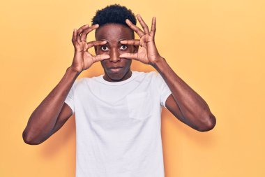 Gündelik giysiler giymiş genç Afro-Amerikan adam parmaklarıyla gözlerini açmaya çalışıyor, uykulu ve yorgun bir şekilde sabah yorgunluğu çekiyor. 