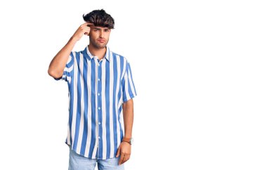 Alnındaki sivilceden mutsuz olduğunu gösteren günlük kıyafetler giyen genç İspanyol adam, siyah başlıklı çirkin enfeksiyon. sivilce ve deri problemi 