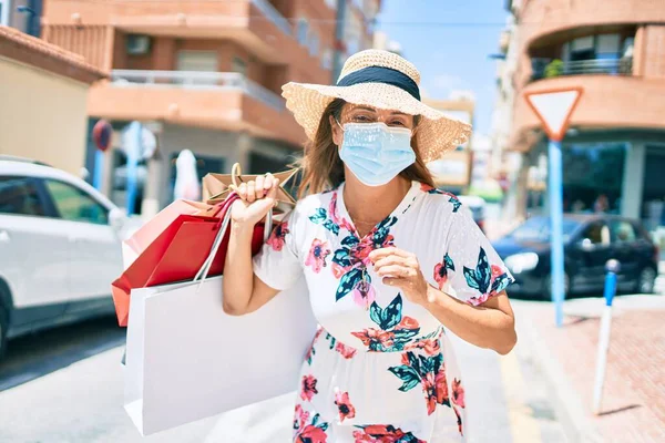Medelålders Latinamerikansk Kvinna Bär Medicinsk Mask Med Shoppingväskor Staden — Stockfoto