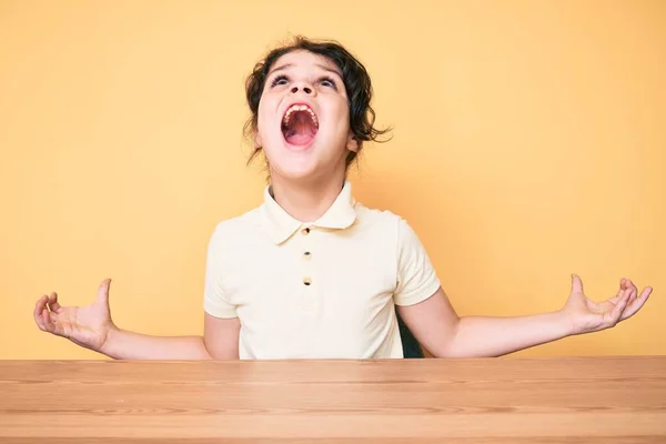 Nettes Hispanisches Kind Lässiger Kleidung Auf Dem Tisch Sitzend Verrückt — Stockfoto