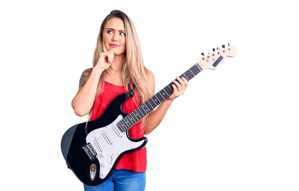 Jovem Bela Mulher Loira Tocando Guitarra Elétrica Rosto Sério Pensando — Fotografia de Stock