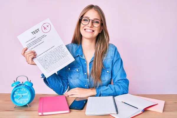 Menina Loira Nova Mostrando Passou Exame Sentado Mesa Olhando Positivo — Fotografia de Stock