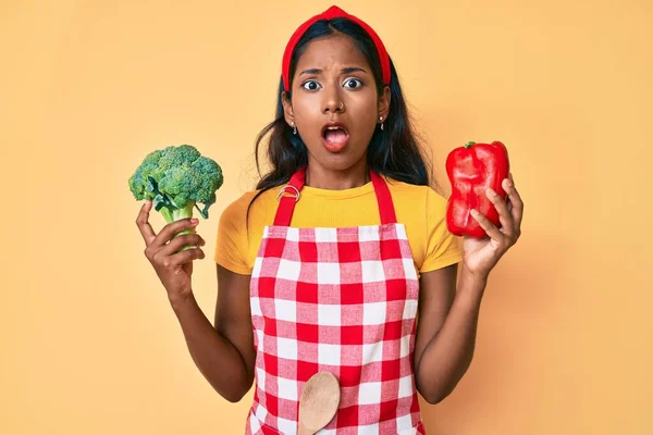 Niña India Joven Con Delantal Sosteniendo Brócoli Pimienta Roja Expresión — Foto de Stock