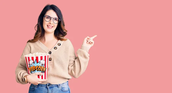 Beautiful Young Brunette Woman Eating Popcorn Smiling Happy Pointing Hand — Stock Photo, Image