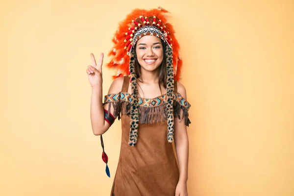 若いです美しいですラテン女の子身に着けていますインディアン衣装ショーとポイントアップとともに指数2同時に笑顔自信と幸せ — ストック写真