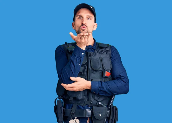 Joven Hombre Guapo Vistiendo Uniforme Policía Mirando Cámara Soplando Beso — Foto de Stock