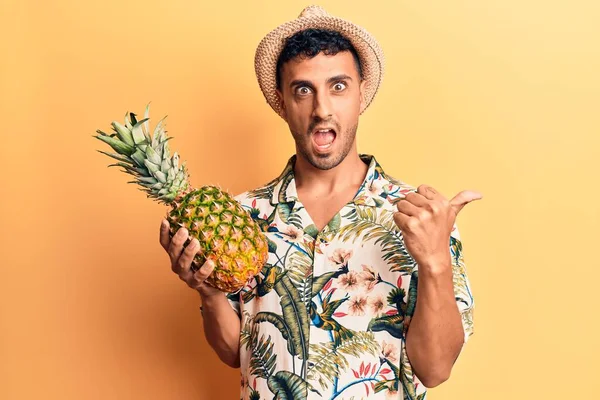 Mladý Hispánec Letním Klobouku Drží Ananas Ukazující Palec Nahoru Stranu — Stock fotografie