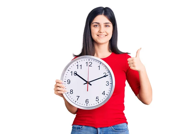 Jovem Menina Bonita Segurando Relógio Sorrindo Feliz Positivo Polegar Para — Fotografia de Stock