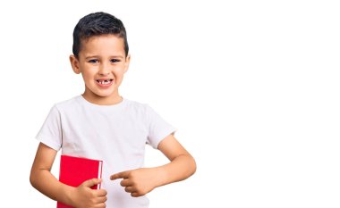 Küçük şirin çocuk kitap okuyor. Gülümsüyor, mutlu bir şekilde elini ve parmağını gösteriyor. 