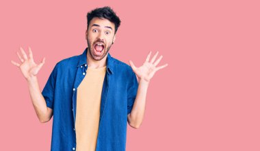 Sıradan kıyafetler giyen genç İspanyol adam çılgın ve başarıyı kollarını kaldırıp heyecanla haykırarak kutluyor. Kazanan konsept 