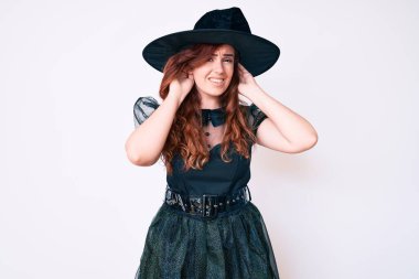 Cadı cadılar bayramı kostümü giymiş genç güzel bir kadın iki elini de kulak hareketi yaparken duymaya çalışıyor, dedikoduya meraklı. İşitme sorunu, sağır 