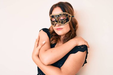 Venedik karnaval maskesi takan güzel beyaz bir kadın mutlu, pozitif ve kendinden emin bir şekilde kendine sarılıyor. Sevgi ve özgüven. 