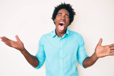Yakışıklı Afro saçlı, sıradan kıyafetler giyen, başarıyı kutlamak için çıldıran, kollarını kaldırmış ve gözleri kapalı heyecanlı bir şekilde bağıran Afro-Amerikan erkeği. Kazanan konsept 