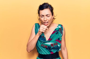 Gündelik kıyafetler giyen, kendini kötü hisseden ve soğuk algınlığı veya bronşitin belirtisi olarak öksüren genç ve güzel İspanyol bir kadın. sağlık hizmeti kavramı. 