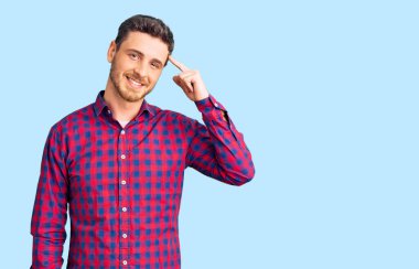 Ayıcık gömleği giymiş yakışıklı genç adam tek parmakla başını gösteren gülümseme, harika fikir ya da düşünce, iyi hafıza 