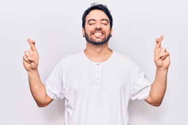 Günlük kıyafetler giyen genç İspanyol adam umut ve gözlerin kapalı gülümseyerek bana işaret etti. Şans ve batıl inançlar. 