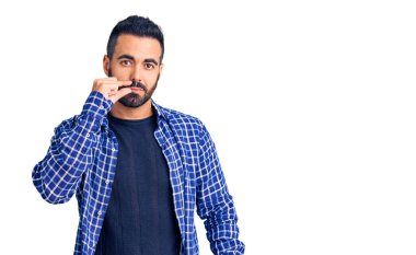 Gündelik kıyafetler giyen genç İspanyol adam ağzı ve dudakları parmaklarıyla kapanan fermuar gibi kapalı. gizli ve sessiz, tabu konuşması 