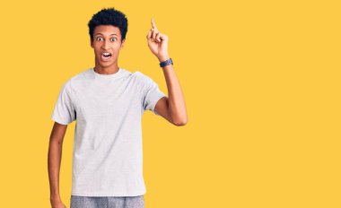 Gündelik giysiler giymiş genç Afro-Amerikan bir adam başarılı bir fikri işaret ediyor. Heyecanlı ve mutlu. Bir numara.. 