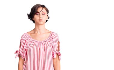 Kısa saçlı, sıradan yaz kıyafetleri giyen, komik yüzlü, yanak şişiren güzel bir kadın. Havayla şişmiş ağız, çılgın bir ifade.. 