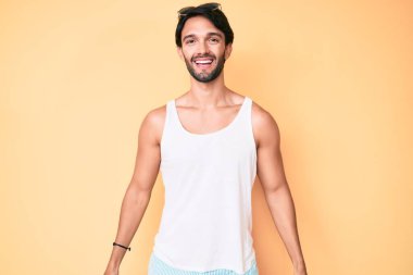 Yazlık görünüm ve güneş gözlüğü takan yakışıklı İspanyol adam. Yüzünde mutlu ve havalı bir gülümseme var. şanslı kişi. 