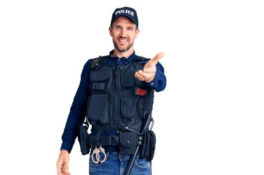 Polis üniforması giyen, neşeli gülümseyen, yardım eli uzatan ve kabullenen genç yakışıklı bir adam.. 