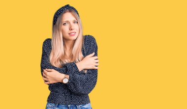 Genç, güzel, sarışın bir kadın. Günlük kıyafetler giyiyor. Kış soğuğu için titriyor ve donuyor. 