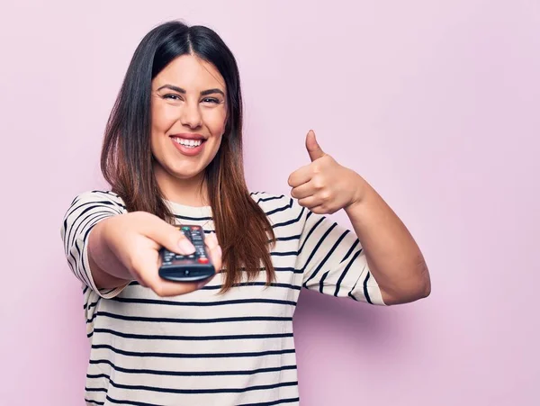 Jong Mooi Brunette Vrouw Houden Televisie Afstandsbediening Roze Achtergrond Glimlachen — Stockfoto