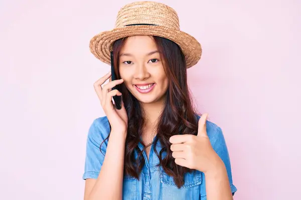年轻美丽的中国姑娘头戴夏帽 在智能手机上与人交谈时面带微笑 面带微笑 泰然自若 泰然自若 — 图库照片