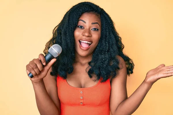 Hermosa Mujer Africana Cantando Canción Usando Micrófono Celebrando Logro Con —  Fotos de Stock