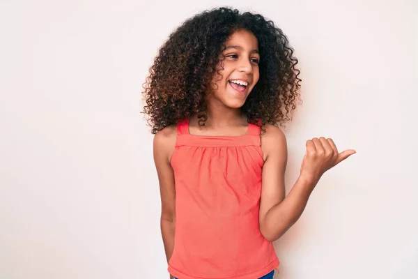 アフリカ系アメリカ人の子供とともに巻き毛を身に着けているカジュアルな服を指差す親指で側笑顔幸せなでオープン口 — ストック写真
