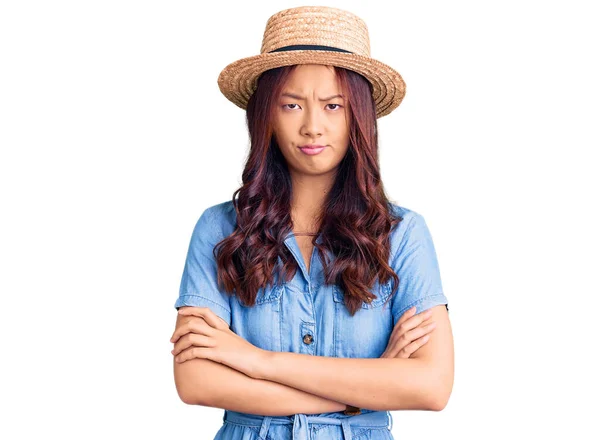 年轻美丽的中国姑娘戴着夏帽 疑神疑鬼 神经质 满脸不赞成的表情 双手交叉 消极的人 — 图库照片