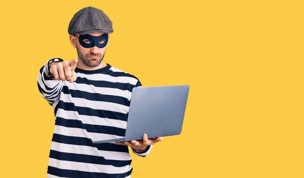 Ung Stilig Man Bär Inbrottstjuv Mask Med Laptop Pekar Med — Stockfoto
